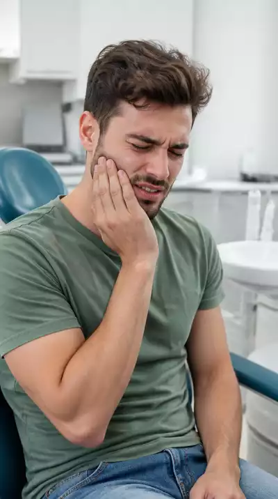 Person holding jaw due to toothache, seeking emergency dental care