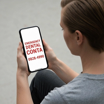 Person holding a phone with emergency dental contact on screen
